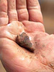 hand holding an ancient artifact from archaeological excavation