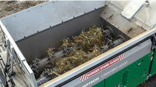 Wood and green waste being efficiently shredded inside the shredding chamber of a Crambo shredder