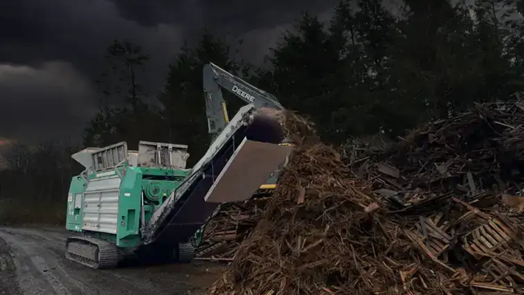 Komptech Crambo Low-Speed, High-Torque, Dual-Shaft Industrial Shredder shredding otganic wood and green waste on site in a remote location. 